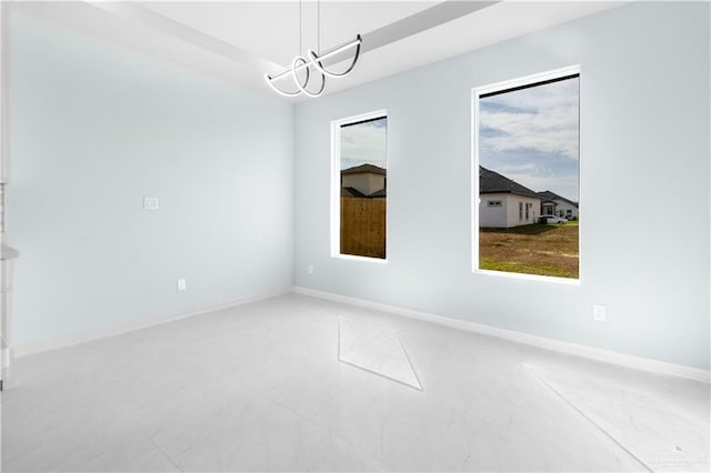 unfurnished room featuring an inviting chandelier