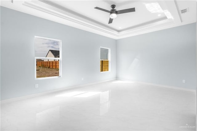 spare room with ceiling fan and a tray ceiling