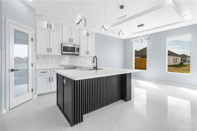 kitchen with white cabinetry, sink, and pendant lighting