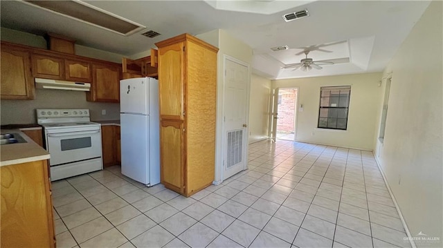 kitchen featuring light tile patterned floors, white appliances, a tray ceiling, and ceiling fan