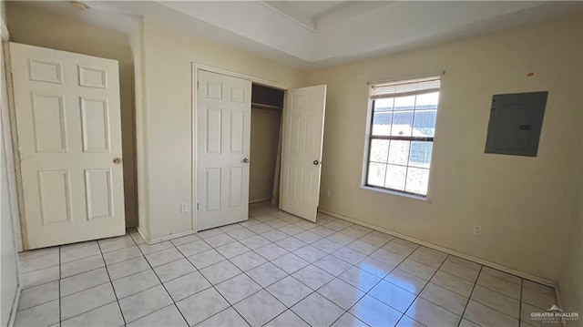 unfurnished bedroom featuring light tile patterned flooring, electric panel, and a closet