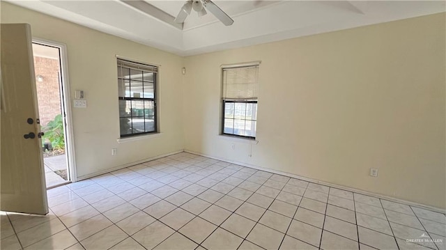 spare room with ceiling fan and light tile patterned flooring