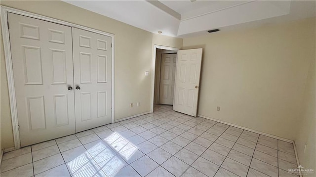 unfurnished bedroom with light tile patterned floors and a closet