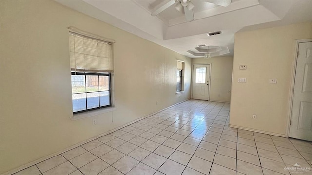 spare room featuring ceiling fan, a raised ceiling, and light tile patterned floors