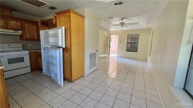 kitchen with a raised ceiling, extractor fan, ceiling fan, electric stove, and light tile patterned floors