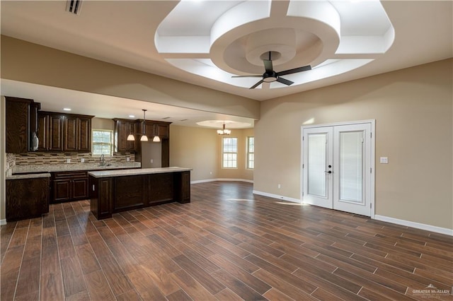 kitchen featuring light countertops, open floor plan, dark wood finished floors, and a center island