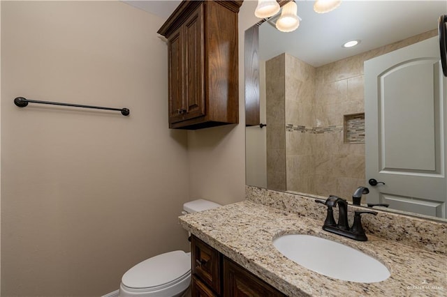 bathroom featuring toilet, baseboards, and vanity