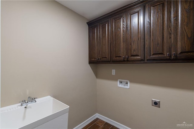 clothes washing area featuring cabinet space, baseboards, hookup for an electric dryer, washer hookup, and a sink