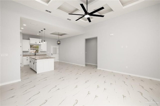 unfurnished living room featuring beamed ceiling, ceiling fan, coffered ceiling, and sink