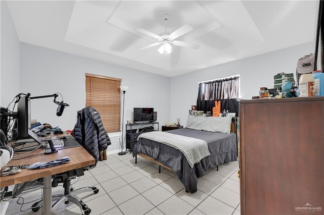 bedroom featuring a raised ceiling, ceiling fan, and light tile patterned floors