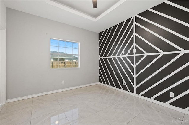 spare room featuring ceiling fan and a tray ceiling