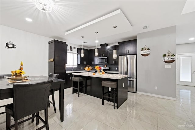 kitchen featuring hanging light fixtures, a kitchen island, a healthy amount of sunlight, and appliances with stainless steel finishes