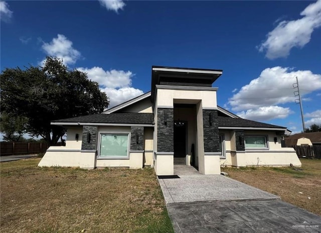 view of front of property with stone siding, fence, and stucco siding