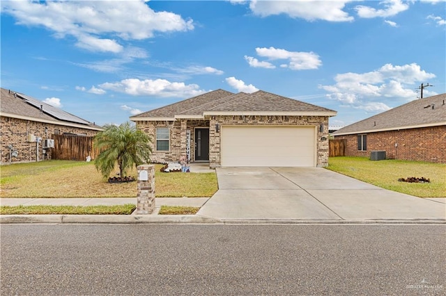 ranch-style house featuring a garage, a front yard, and central air condition unit