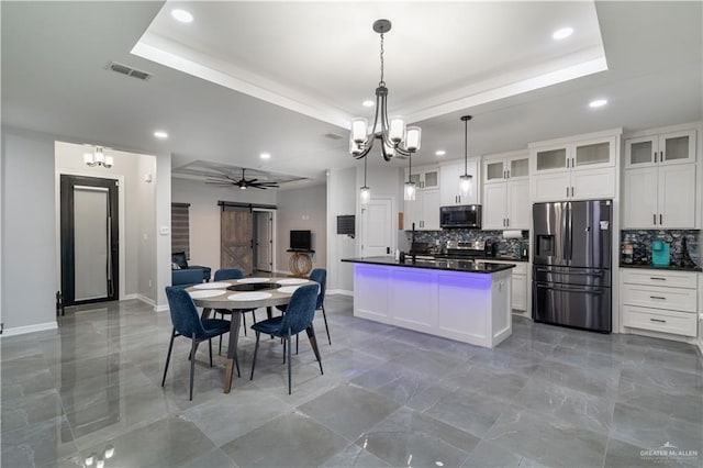 kitchen with stainless steel appliances, a raised ceiling, and white cabinets