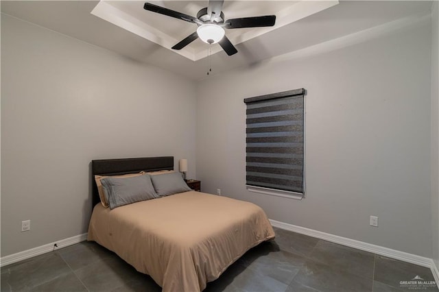 bedroom with a raised ceiling and ceiling fan