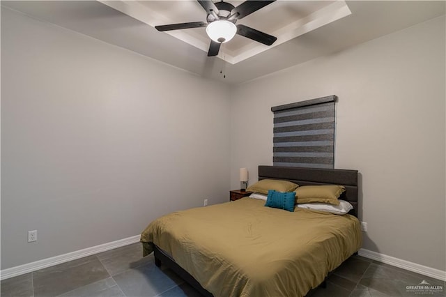 bedroom featuring a raised ceiling and ceiling fan