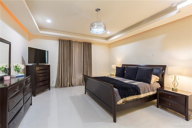 bedroom with light tile patterned floors and a tray ceiling