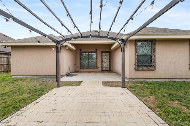 view of exterior entry with a patio and a lawn