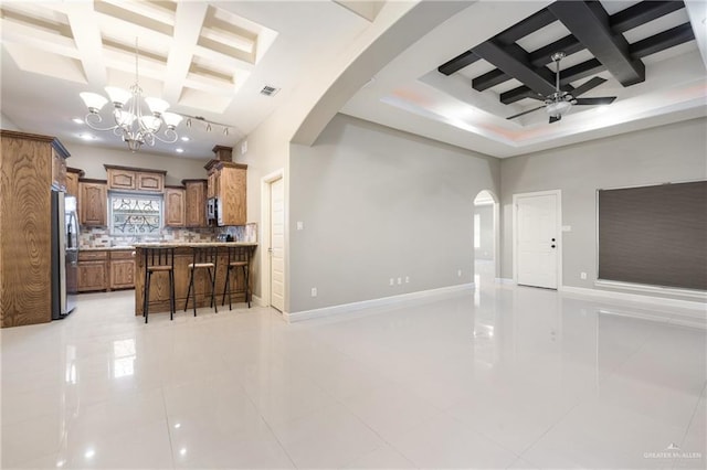 interior space with beamed ceiling, coffered ceiling, and ceiling fan with notable chandelier