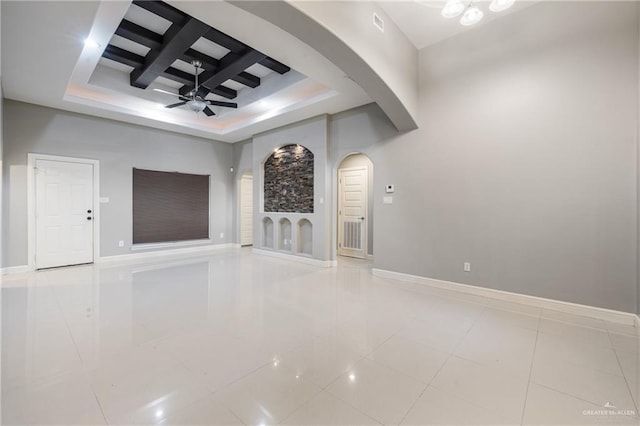 unfurnished living room with beam ceiling, coffered ceiling, tile patterned flooring, and ceiling fan