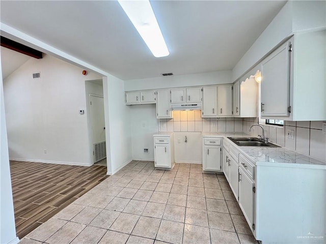 1313 Royal Palm St, Alamo, TX 78516 - kitchen with a sink, backsplash, under cabinet range hood, white cabinets, and beamed ceiling