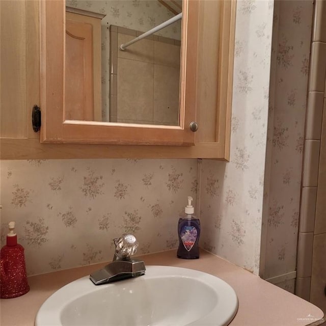 bathroom with a tile shower and sink