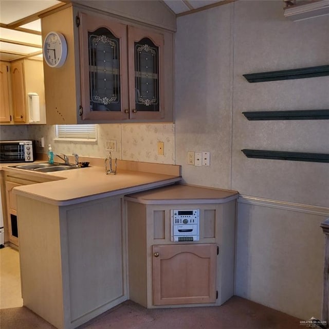 kitchen featuring light carpet, kitchen peninsula, and sink