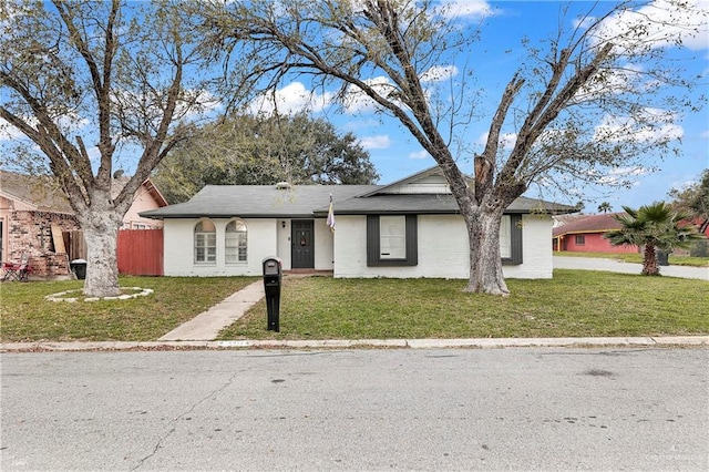 ranch-style home with brick siding, a front yard, and fence