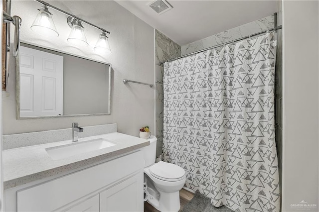 bathroom with curtained shower, visible vents, vanity, and toilet