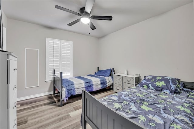 bedroom featuring ceiling fan, light wood-style flooring, and baseboards