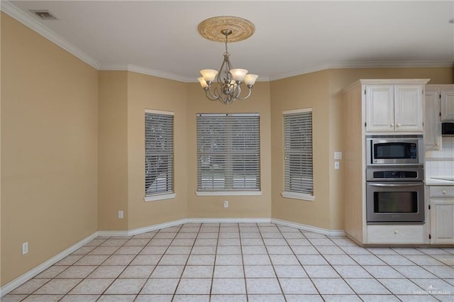 kitchen featuring light tile patterned floors, a chandelier, white cabinets, appliances with stainless steel finishes, and crown molding