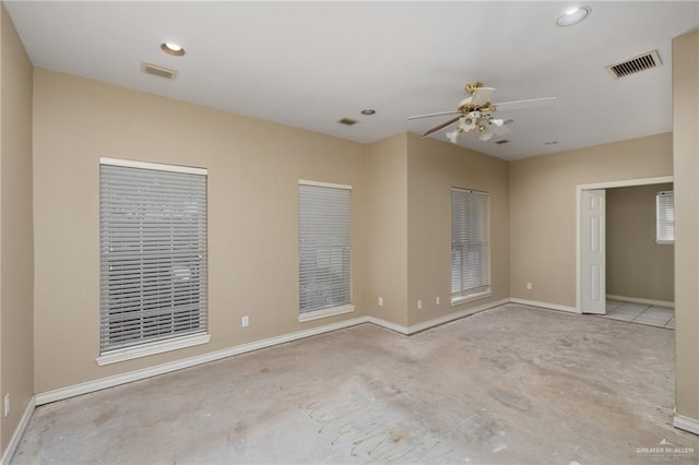 unfurnished room featuring ceiling fan, visible vents, concrete flooring, and baseboards