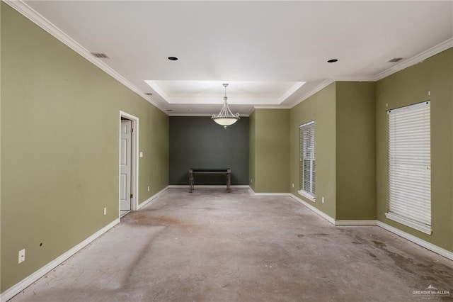 spare room with concrete floors, visible vents, baseboards, a tray ceiling, and crown molding