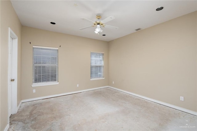 empty room with baseboards, concrete floors, visible vents, and a ceiling fan