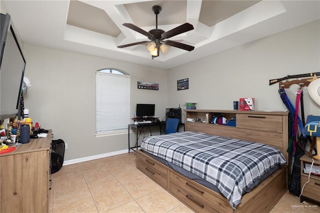 tiled bedroom featuring a raised ceiling and ceiling fan