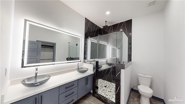 bathroom featuring vanity, a shower with shower door, and toilet