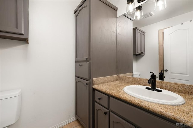 bathroom featuring tile patterned floors, vanity, and toilet