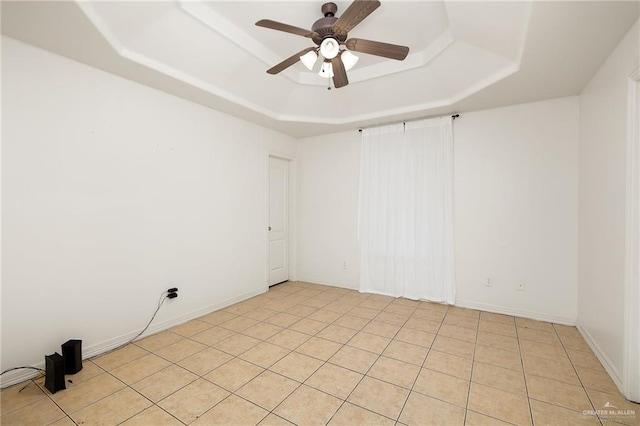 empty room featuring a raised ceiling and ceiling fan