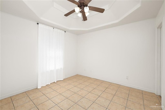 spare room with light tile patterned flooring, ceiling fan, and a tray ceiling