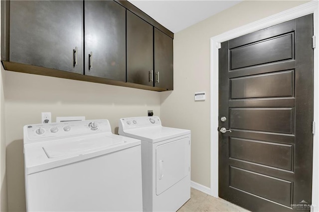 laundry area with independent washer and dryer, cabinets, and light tile patterned flooring