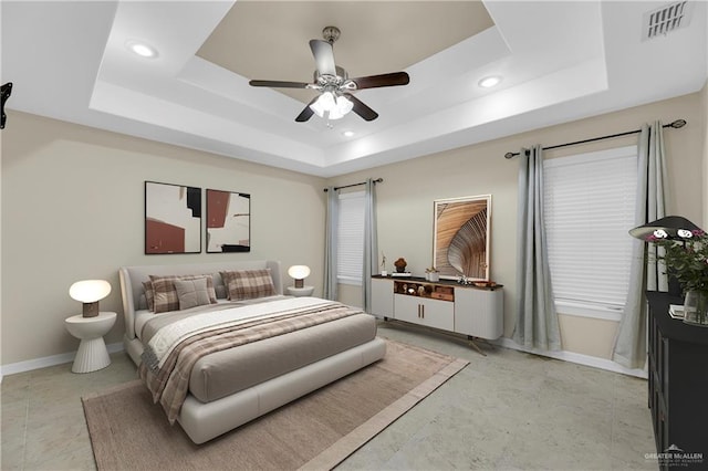 bedroom with a tray ceiling and ceiling fan