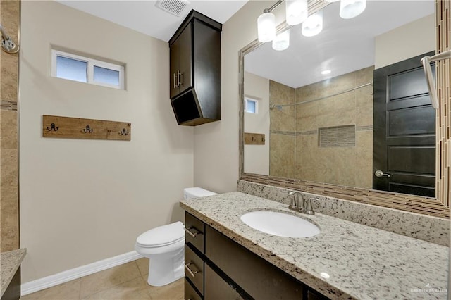 bathroom featuring tile patterned flooring, vanity, a tile shower, and toilet