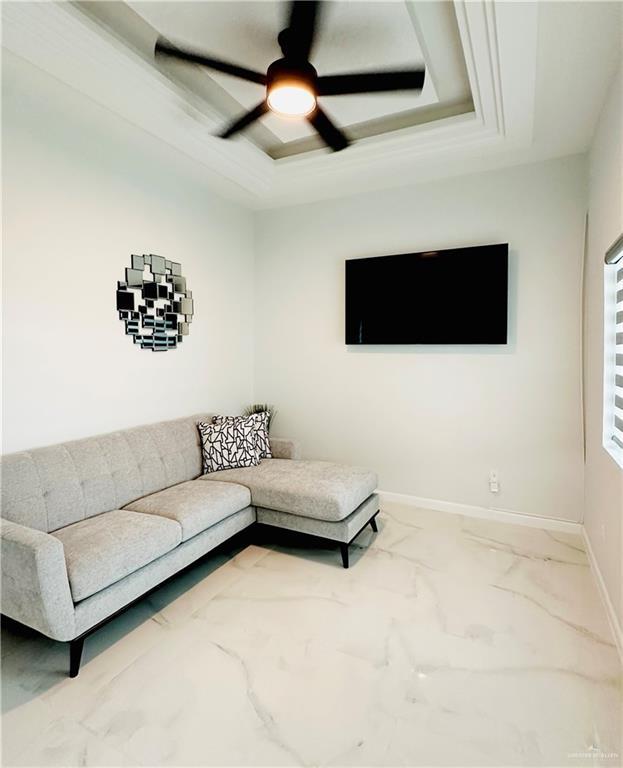 1509 Giselle St, Mission, TX 78574 - living room with a tray ceiling, ceiling fan, marble finish flooring, and baseboards