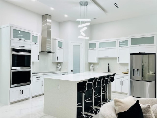 1509 Giselle St, Mission, TX 78574 - kitchen with appliances with stainless steel finishes, wall chimney range hood, tasteful backsplash, light countertops, and a kitchen island