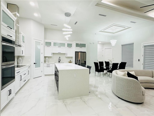 1509 Giselle St, Mission, TX 78574 - kitchen featuring stainless steel appliances, a sink, light marble finish flooring, white cabinetry, and pendant lighting