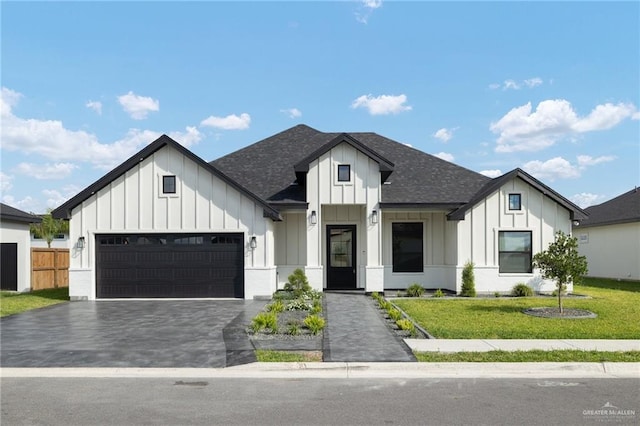 modern inspired farmhouse with an attached garage, a shingled roof, decorative driveway, and board and batten siding