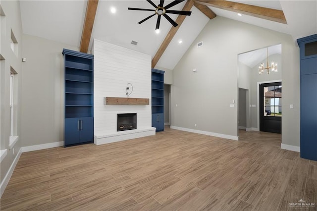 unfurnished living room featuring a large fireplace, high vaulted ceiling, beamed ceiling, and light wood-type flooring