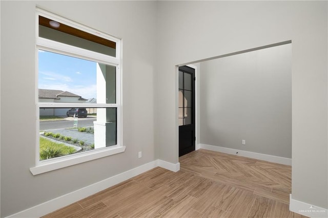 empty room featuring parquet flooring and baseboards