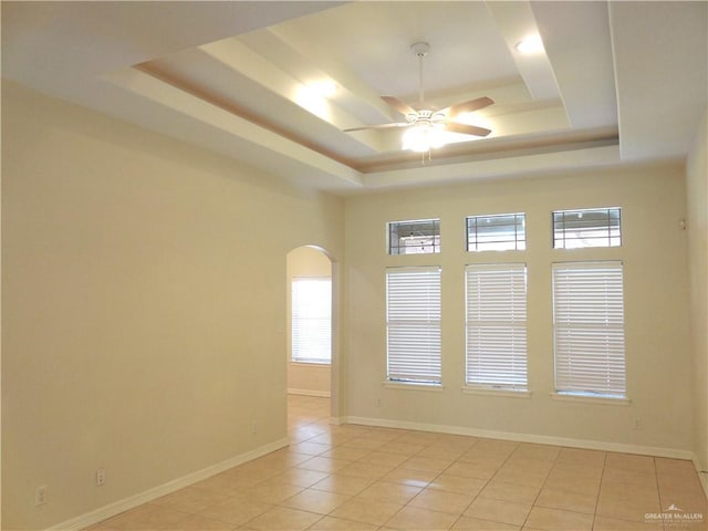 3519 Aspen Dr, Edinburg, TX 78542 - empty room featuring a tray ceiling, ceiling fan, arched walkways, and light tile patterned floors